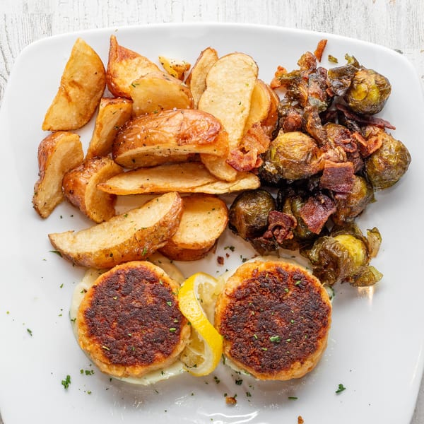 White Wolf Cafe's crab cakes with lemon, roasted potatoes, and crispy Brussels sprouts with bacon.