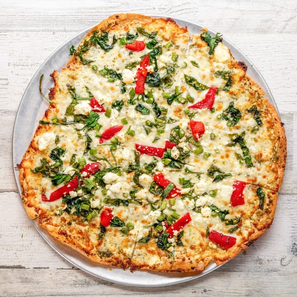 White Wolf Cafe's flatbread pizza topped with cheese, spinach, red peppers, and green onions.